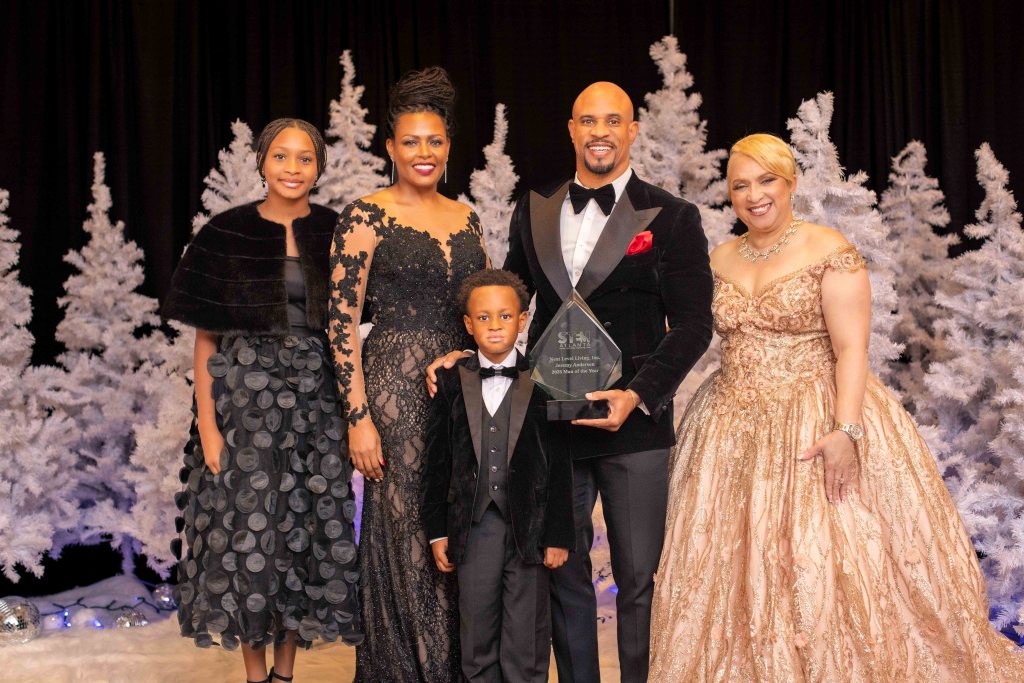 Jeremy Anderson, Man of the Year award recipient, posing with his wife and kids at the STEMii Awards captured by Omni Worldwide event photography.